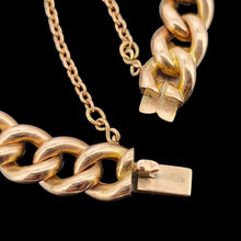 Load image into Gallery viewer, A rose gold curb link bracelet, with a safety chain, on a black background