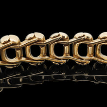 Load image into Gallery viewer, An oval link bracelet in yellow gold, on a black background