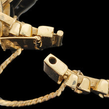 Load image into Gallery viewer, A close-up of a yellow gold bracelet clasp and safety chain, on a black background