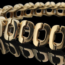 Load image into Gallery viewer, An oval link bracelet in yellow gold, on a black background