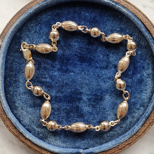 Load image into Gallery viewer, Gold bracelet on a blue cushioned antique jewellery box