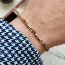 Load image into Gallery viewer, A yellow gold tube link bracelet modelled on a wrist