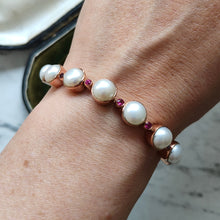Load image into Gallery viewer, A pearl and ruby bracelet in rose gold, modelled on a wrist