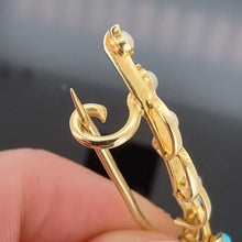 Load image into Gallery viewer, Gold brooch clasp held by a hand against a dark background