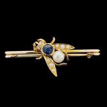 Load image into Gallery viewer, A yellow gold fly bar brooch with sapphire, pearls and diamond eyes, on a black background