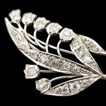 Load image into Gallery viewer, A white gold lily of the valley floral brooch set with diamonds, on a black background