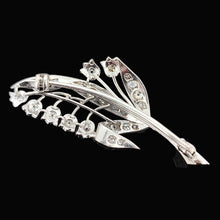 Load image into Gallery viewer, A white gold lily of the valley floral brooch set with diamonds, on a black background