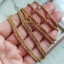 Load image into Gallery viewer, A yellow gold twisted rope chain with a bolt ring clasp, held in a hand