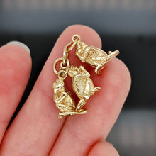 Load image into Gallery viewer, Three wise monkeys charm in yellow gold, held in a hand