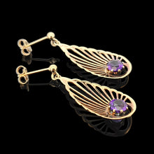 Load image into Gallery viewer, A pair of pear shaped fan design drop earrings with amethysts in yellow gold, on a black background