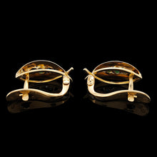 Load image into Gallery viewer, A pair of yellow gold turquoise leaf shaped earrings, on a black background