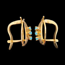 Load image into Gallery viewer, A pair of yellow gold turquoise leaf shaped earrings, on a black background