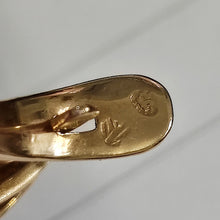 Load image into Gallery viewer, A close-up of unknown stamps on a yellow gold earring fitting