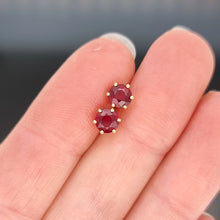 Load image into Gallery viewer, 18ct Yellow Gold Ruby Solitaire Stud Earrings held in the hand