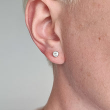 Load image into Gallery viewer, Close-up of an ear wearing a diamond stud earring against a neutral background
