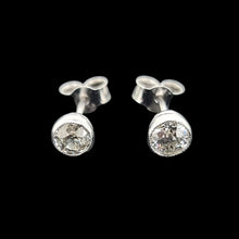 Load image into Gallery viewer, Pair of platinum stud earrings with diamonds on a black background