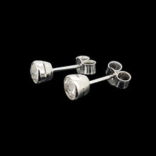 Load image into Gallery viewer, Pair of platinum stud earrings on a black background