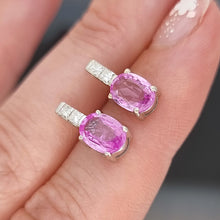 Load image into Gallery viewer, Pink sapphire and diamond earrings on a hand