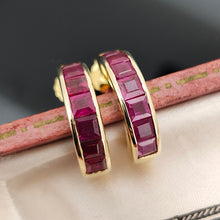 Load image into Gallery viewer, A pair of yellow gold hoop earrings channel set with square cut rubies