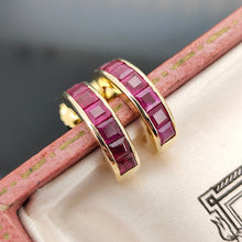 Load image into Gallery viewer, A pair of yellow gold hoop earrings channel set with square cut rubies