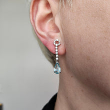 Load image into Gallery viewer, An aquamarine and diamond drop earring in white gold, modelled in an ear