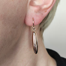 Load image into Gallery viewer, A rose gold elongated drop earring with a hook fitting, modelled in an ear
