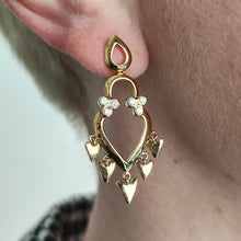 Load image into Gallery viewer, A yellow gold open heart shaped drop earring with diamonds, modelled in an ear
