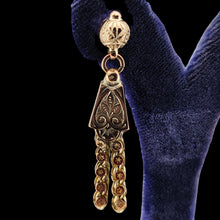 Load image into Gallery viewer, Close-up of a yellow gold fancy engraved tassel drop earring, in an earring stand