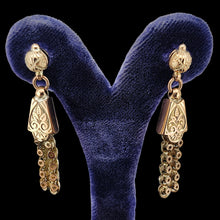 Load image into Gallery viewer, A pair of yellow gold fancy engraved tassel drop earrings, in an earring stand