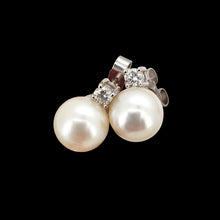 Load image into Gallery viewer, A pair of white pearl and round diamond stud earrings in white gold, on a black background