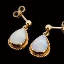 Load image into Gallery viewer, A pair of pear shaped opal drop earrings in yellow gold, on a black background
