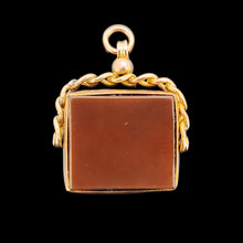 Load image into Gallery viewer, A carnelian swivel fob in yellow gold, on a black background