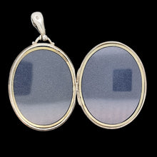 Load image into Gallery viewer, Silver locket with two oval compartments on a black background