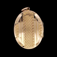 Load image into Gallery viewer, An oval yellow gold locket pendant with engraving, against a black background