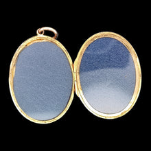 Load image into Gallery viewer, A yellow gold locket pendant, open, showing the inside, against a black background