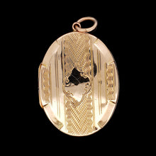 Load image into Gallery viewer, An oval yellow gold locket pendant with engraving, against a black background