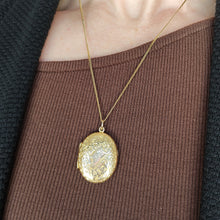 Load image into Gallery viewer, An intricately engraved oval locket in yellow gold, with a banner with monogrammed initials reading FP, modelled with a chain