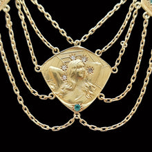 Load image into Gallery viewer, Gold necklace with a decorative pendant featuring a face and gemstones on a black background