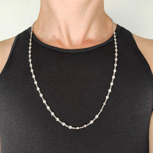 Load image into Gallery viewer, A white gold round diamond station necklace, modelled by a woman wearing a black top