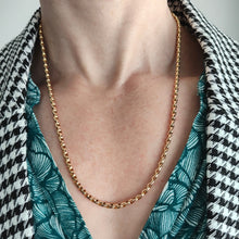 Load image into Gallery viewer, A yellow gold faceted link chain necklace, modelled by a woman wearing a green top and houndstooth print jacket