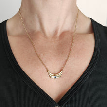 Load image into Gallery viewer, A yellow gold pendant necklace with a round aquamarine, modelled by a woman