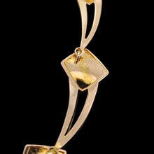 Load image into Gallery viewer, A close-up of the reverse of a gold link from a vintage necklace, against a black background