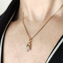 Load image into Gallery viewer, A yellow and white gold diamond set leaf shaped pendant, modelled on a gold chain by a woman