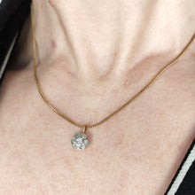 Load image into Gallery viewer, A flower shaped diamond cluster pendant in yellow gold and platinum, modelled on a gold chain by a woman