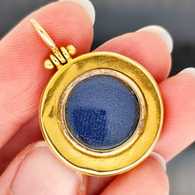 Load image into Gallery viewer, An antique locket back pendant in yellow gold, held in a hand