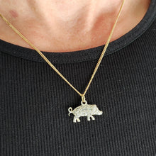 Load image into Gallery viewer, A diamond and ruby set silver pig charm with a gold jump ring, with a gold chain, modelled by a woman wearing a black top