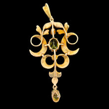 Load image into Gallery viewer, A peridot and pearl Art Nouveau style pendant in yellow gold, on a black background