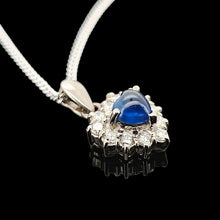 Load image into Gallery viewer, A heart shaped sapphire and diamond cluster pendant, with a curb link chain, on a black background