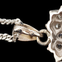 Load image into Gallery viewer, A close-up of a 750 18 carat stamp on a pendant bale, with a curb link chain, on a black background