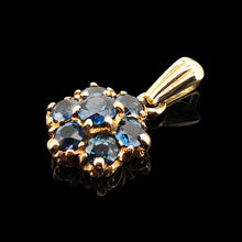 Load image into Gallery viewer, A yellow gold pendant with seven round sapphires, on a black background